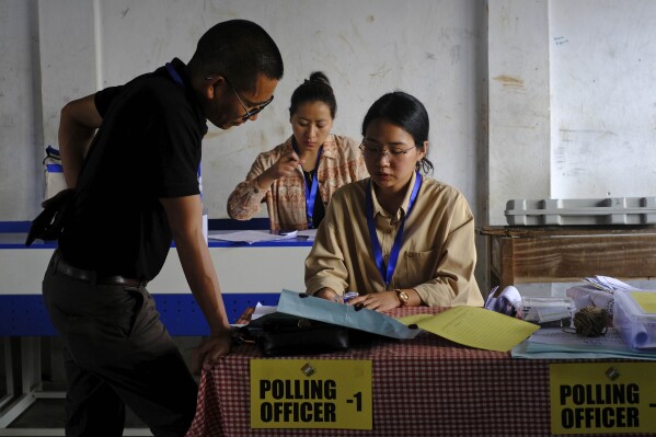 Zhoto Khamo oversees paperwork prepared by polling officer Neke W Konyak, 29, on the eve of polling in Chedema village, in the northeastern Indian state of Nagaland, Thursday, April 18, 2024. (AP Photo/Yirmiyan Arthur)