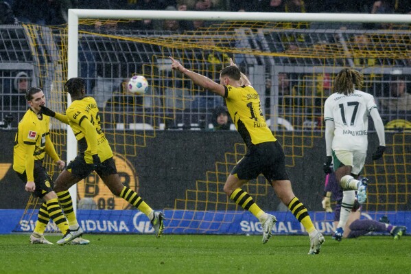 Dortmund's Jamie Bynoe-Gittens, second left, scores his side's third goal during the German Bundesliga soccer match between Borussia Dortmund and Borussia Moenchengladbach in Dortmund, Germany, Saturday, Nov. 25, 2023. (Bernd Thissen/dpa via AP)