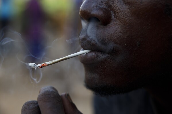 A young man smokes Kush at a hideout in Freetown, Sierra Leone, Monday, April 29, 2024. Sierra Leone declared a war on the cheap synthetic drug, calling it an epidemic and a national threat. The drug is ravaging youth, and healthcare services are severely limited. (AP Photo/ Misper Apawu)