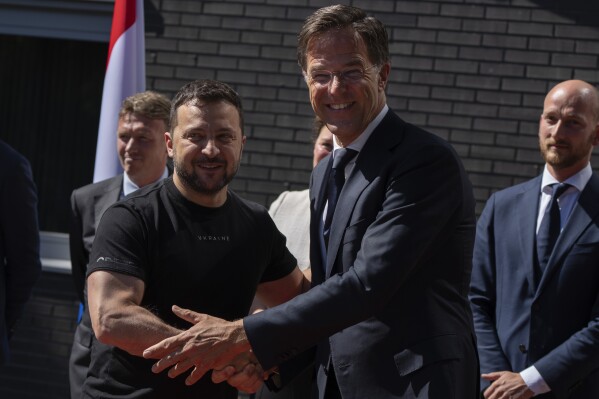 Ukrainian President Volodymyr Zelenskyy, left, is greeted by Dutch caretaker Prime Minister Mark Rutte in Eindhoven, Netherlands, Sunday, Aug. 20, 2023. The leaders met at a military air base in the southern Dutch city, a day after Zelenskyy visited Sweden on his first foreign trip since attending a NATO summit in Lithuania last month. On Friday, the Netherlands and Denmark said that the United States had given its approval for the countries to deliver F-16s to Ukraine. (AP Photo/Peter Dejong)
