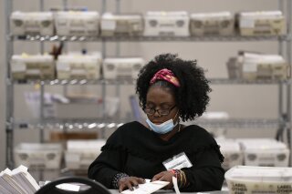 Cobb County Election officials handle ballots during an audit, Monday, Nov. 16, 2020, in Marietta, Ga. A hand tally of the nearly 5 million votes cast in the presidential race in Georgia has entered its fourth day Monday. (AP Photo/Mike Stewart)