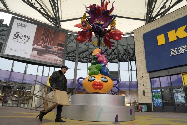 A security guard prepares for duty at a retail district in Beijing, Wednesday, Nov. 15, 2023. China's economy showed more signs of reviving in October as retail sales and manufacturing picked up though the property sector remained sluggish, the government said Wednesday. (AP Photo/Ng Han Guan)