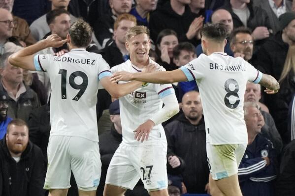 Burnley's Matej Vydra, center, celebrates after scoring his side's opening goal during the English Premier League soccer match between Chelsea and Burnley at the Stamford Bridge stadium in London, Saturday, Nov. 6, 2021. (AP Photo/Frank Augstein)