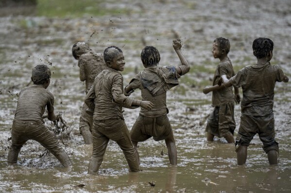 Children play in the mud in a paddy field during Asar Pandra, or paddy planting day at Bahunbesi, Nuwakot District, 30 miles North from Kathmandu, Nepal, Friday, June 30, 2023. Nepalese people celebrate the festival by planting paddy, playing in the mud, singing traditional songs, eating yogurt and beaten rice.(AP Photo/Niranjan Shrestha)