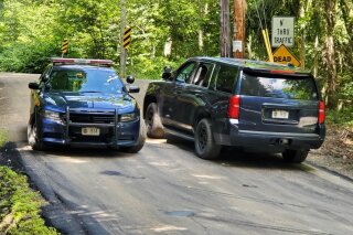 New York State Police block off a road near the scene where the body of Roy Den Hollander was found on Monday, July 20, 2020 near Livingston Manor, N.Y. Hollander, a self-described "anti-feminist" lawyer found dead in the Catskills of an apparent self-inflicted gunshot wound, is being investigated as the possible gunman in the shooting of a federal judge's family in New Jersey. (Jim Sabastian/The Times Herald-Record via AP)