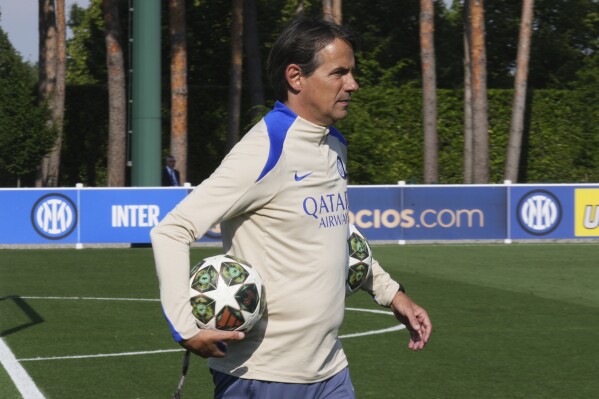 Inter Milan's head coach Simone Inzaghi holds a ball during a training session of the Champions League Media Day in view of the Saturday's Champions League final against PSG, at the Inter Milan training center, in Appiano Gentile, Italy, Monday, May 26, 2025. (AP Photo/Antonio Calanni)