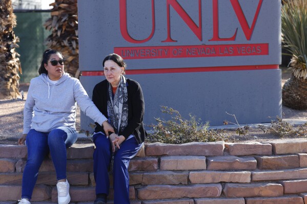 Two women sit after a shooting on the University of Nevada, Las Vegas, campus on Wednesday, Dec. 6, 2023, in Las Vegas. (Bizuayehu Tesfaye/Las Vegas Review-Journal via AP)