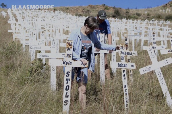 Anita de Lange, left, and her son, Hansie de Lange, tidy up at the Witkruis Monument, near Polokwane, South Africa, May 24, 2025. (AP Photo/Mogomotsi Magome)