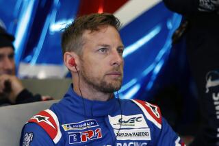 FILE - Britain's driver Jenson Button waits in stand during the 86th 24-hour Le Mans endurance race, in Le Mans, western France, Saturday, June 16, 2018. Button will make his NASCAR debut at Circuit of the Americas later this month in a car funded by longtime sponsor Mobil 1 and prepared by Stewart-Haas Racing. Button joins Kimi Raikkonen in the race – marking two former Formula One world champions in the lineup on the permanent road course in Austin, Texas. (AP Photo/Thibault Camus, File)