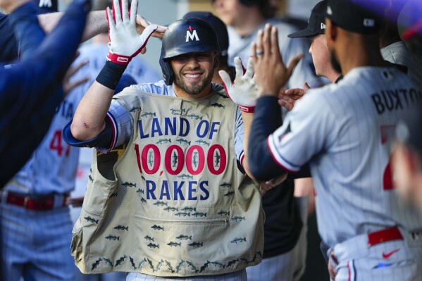 Minnesota Twins' Alex Kirilloff wears a fishing vest in the dugout to celebrate his two-run home run against the Seattle Mariners during the third inning of a baseball game, Tuesday, July 18, 2023, in Seattle. (AP Photo/Lindsey Wasson)