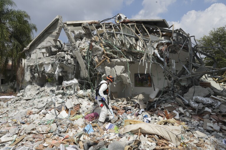 An Israeli soldier walks by the wreckage of a house destroyed by Hamas militants in Kibbutz Be'eri on Oct. 11, 2023. The kibbutz was overrun by Hamas militants from Neraby Gaza Strip Saturday when they killed and captured many Israelis. (AP Photo/Baz Ratner)