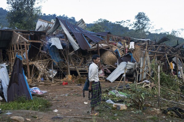 A man looks on at homes destroyed after air and artillery strikes in Mung Lai Hkyet displacement camp, in Laiza, Myanmar, Tuesday Oct. 10, 2023. Myanmar’s military is accused of launching an airstrike on a camp for displaced persons in the northern state of Kachin that killed about 30 people, including about a dozen children. A local Kachin human rights group said the attack on the Mung Lai Hkyet displacement camp in the northern part of Laiza, a town where the headquarters of the rebel Kachin Independence Army is based, also wounded about 60 people. (AP Photo)