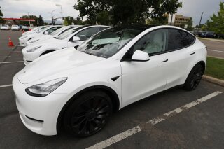 FILE - In this Sunday, June 28, 2020 file photo, 2020 Model Y electric sports-utility vehicles sit in the parking lot of a Tesla store in Littleton, Colo. Tesla overcame a seven-week pandemic-related shutdown at its U.S. assembly plant to post a $104 million net profit for the second quarter. (AP Photo/David Zalubowski)