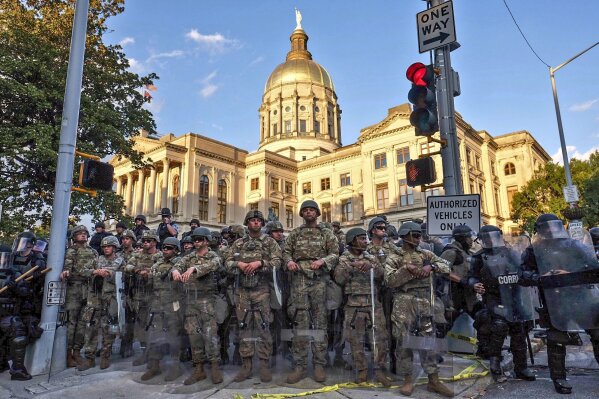 Authorities stand guard in the area around the Georgia state Capitol as protests continued for a third day in Atlanta on Sunday, May 31, 2020. Protests were held in U.S. cities over the death of George Floyd, a black man who died after being restrained by Minneapolis police officers on May 25. (Ben Gray/Atlanta Journal-Constitution via AP)