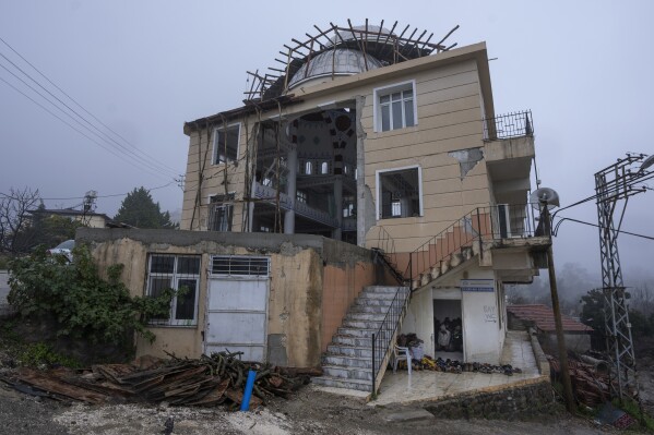 Worshippers attend Friday prayers at a mosque that was partially destroyed during the powerful Feb.6, 2023 earthquake in Antakya, southern Turkey, Friday, Jan. 12, 2024. A year after the devastating tremor, many in the region are struggling to rebuild lives. (AP Photo/Khalil Hamra)
