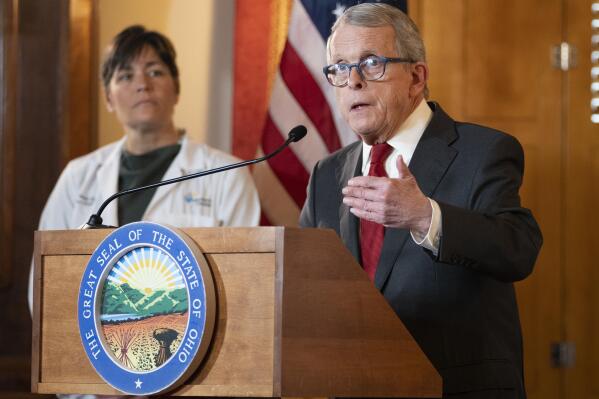Ohio Gov. Mike DeWine speaks during a news conference as Dr. Sara Bode of Nationwide Children's Hospital stands behind him after he vetoed legislation that would have blocked cities like Columbus from banning the sale of menthol cigarettes and flavored vapes, Thursday, Jan. 5, 2023. (Brooke LaValley/The Columbus Dispatch via AP)