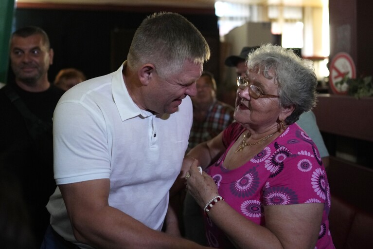 Former Slovak Prime Minister and head of leftist SMER - Social Democracy party Robert Fico, left, greets a supporter during an election rally in Michalovce, Slovakia, Wednesday, Sept. 6, 2023. Fico, who led Slovakia from 2006 to 2010 and again from 2012 to 2018, might reclaim the prime minister's office after the Sept. 30 election. He and his left-wing Direction ("Smer")-Social Democracy party have campaigned on a clear pro-Russian and anti-American message. (AP Photo/Petr David Josek)