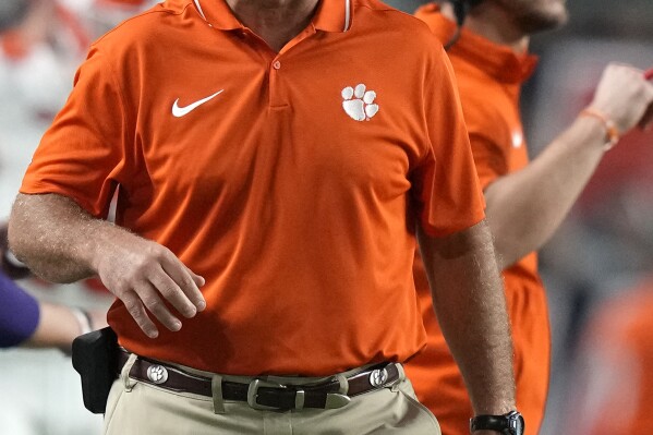 Clemson head coach Dabo Swinney walks along the sideline during the first half of an NCAA college football game against Miami, Saturday, Oct. 21, 2023, in Miami Gardens, Fla. (AP Photo/Lynne Sladky)