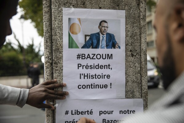 Demonstrators gather in front of the Embassy of Niger in Paris, in support of Nigerien President Mohamed Bazoum and ECOWAS, Saturday, Aug. 5, 2023. (AP Photo/Sophie Garcia)