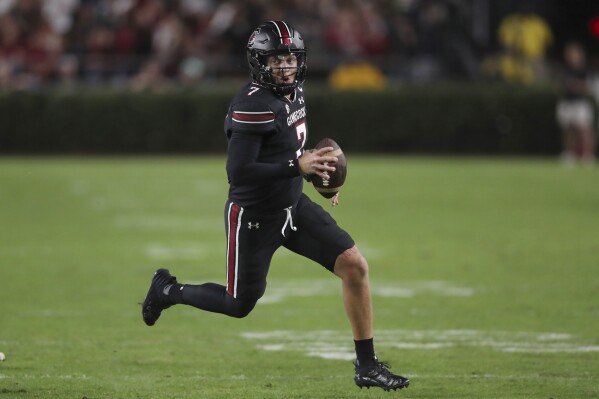 FILE - South Carolina quarterback Spencer Rattler (7) runs for a first down during the first half of an NCAA college football game against Kentucky on Saturday, Nov. 18, 2023, in Columbia, S.C. South Carolina's best playmakers on offense the past two years are all gone, meaning this spring is a search for consistency and production from an attack that had its struggles last season. With Rattler and Xavier Legette awaiting NFL draft picks — Legette a likely first-rounder, Rattler a mid-round choice — it's up to inexperienced newcomers and transfers to push the Gamecocks forward. (AP Photo/Artie Walker Jr., File)