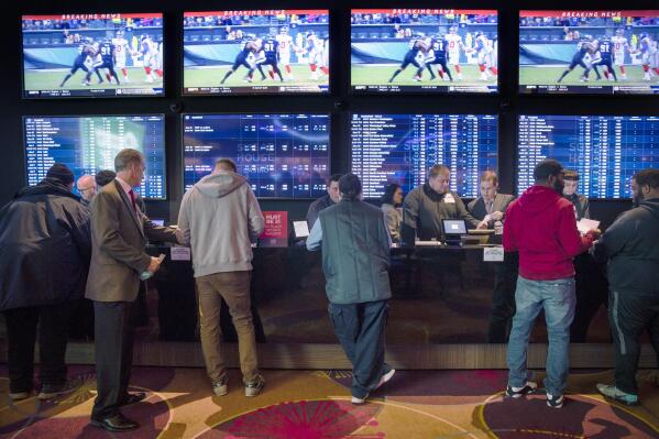 FILE - In this Dec. 13, 2018, file photo, gamblers place bets in the temporary sports betting area at the SugarHouse Casino in Philadelphia. State regulators said Monday, July 19, 2021, that Pennsylvania smashed its record for gambling revenue, reporting nearly $3.9 billion in the last fiscal year as every category of wagering showed growth in one of the nation's largest casino and gambling states. (AP Photo/Matt Rourke, File)