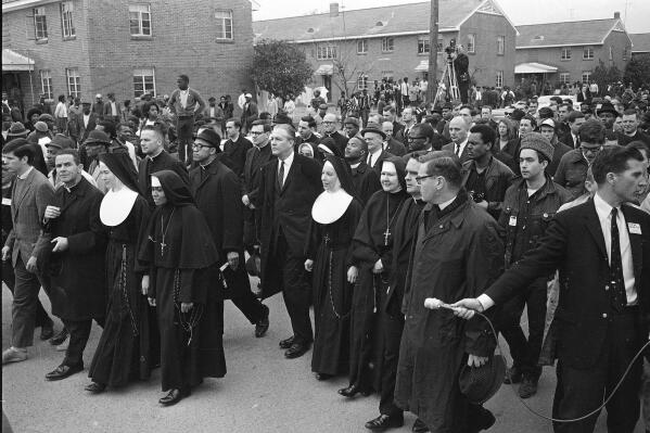 FILE - Six Catholic nuns, including Sister Mary Antona Ebo, front row fourth from left, lead a march in Selma, Ala., on March 10, 1965, in support of Black voting rights and in protest of the violence of Bloody Sunday when white state troopers brutally dispersed peaceful Black demonstrators. The group was within a hundred feet of a black church when the police blocked their way. (AP Photo/File)