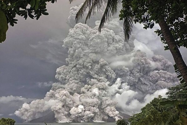 In this photo released by the Vulcanology and Geological Disaster Mitigation Center (PVMBG) of the Indonesian Ministry of Energy and Mineral Resources, Mount Ruang releases volcanic materials during its eruption, Tuesday, April 30, 2024, on Sulawesi Island, Indonesia. Indonesia's Mount Ruang volcano erupted Tuesday for a second time in two weeks, spewing ash almost 2 kilometers (more than a mile) into the sky, closing an airport and peppering nearby villages with debris. (PVMBG via AP Photo)
