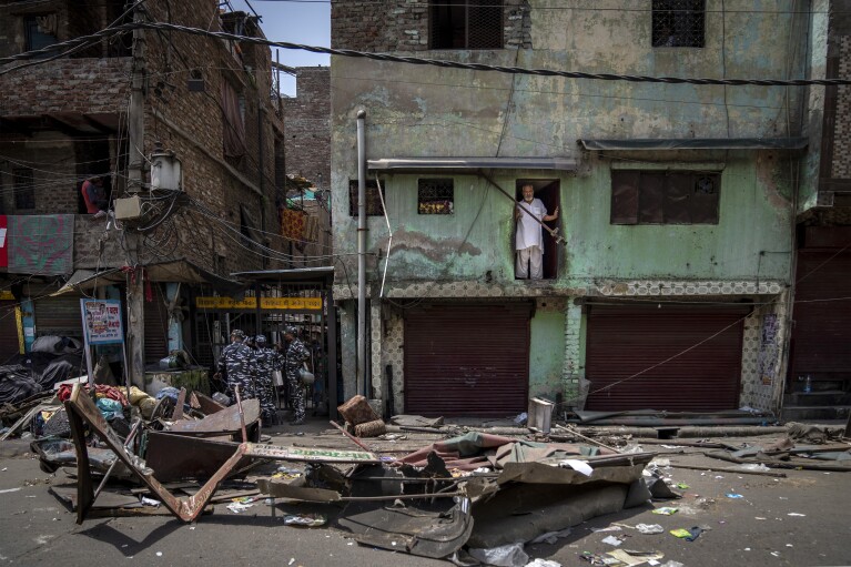 FILE- A Muslim man looks from his house after a shop was demolished during a Hindu religious procession that turned violent in New Delhi, India, April 20, 2022. Authorities riding bulldozers razed a number of Muslim-owned shops before India's Supreme Court halted the demolitions. (AP Photo/Altaf Qadri, File)