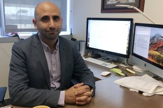 
              Dr. Fatta Nahab, a neurologist who directs the Functional Imaging of Neurodegenerative Disorders Lab at the University of California San Diego Health's Movement Disorder Center, sits at his desk Monday, Sept 17, 2018, in San Diego. Nahab spent years going through regulatory hoops to get approval to import marijuana from Canada, to study whether cannabis can help treat essential tremor, a shaking condition affecting millions of people. (AP Photo/Julie Watson)
            