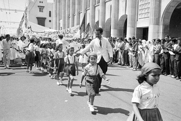 FILE - Children march in a parade during official independence celebrations in Algiers, Algeria, on July 5, 1962. Algeria is celebrating 60 years of independence from France on Tuesday July 5, 2022 with nationwide ceremonies, a pardon of 14,000 prisoners and its first military parade in years. Tuesday's events mark 60 years since the official declaration of independence on July 5, 1962, after a brutal seven-year war which ended 132 years of colonial rule. The war, which killed at least 1.5 million people, remains a point of tension in relations between Algeria and France. (AP Photo, File)