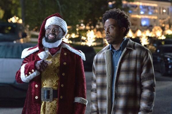 This image released by Disney+ shows Lil Rel Howery as Nick, left, and Chris "Ludacris" Bridges as Eddie in a scene from the holiday special "Dashing Through the Snow." (Steve Dietl/Disney+ via AP)