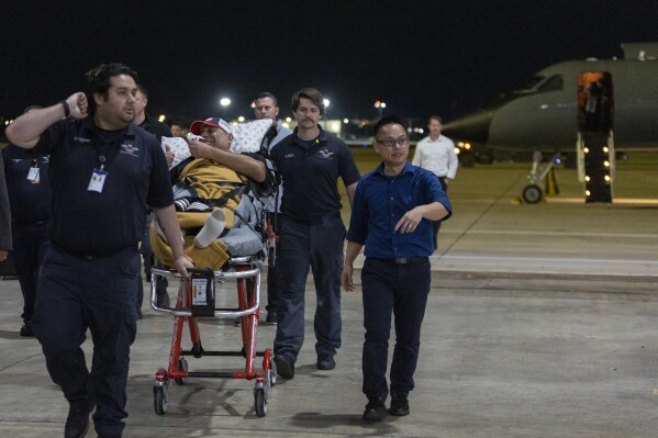 Freed American Edgar Jose Marval Moreno is assisted by medical professionals upon arrival at Kelly Airfield Annex, after he and nine fellow detainees were released in a prisoner swap deal between U.S. and Venezuela, Wednesday, Dec. 20, 2023, in San Antonio, Texas. Six of the Americans released arrived at Kelly Airfield Annex. (AP Photo/Stephen Spillman)