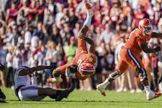 South Carolina linebacker Debo Williams (0) tackles Clemson quarterback DJ Uiagalelei (5) in the first half of an NCAA college football game on Saturday, Nov. 26, 2022, in Clemson, S.C. (AP Photo/Jacob Kupferman)