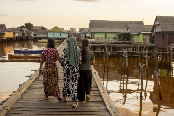 People walk through Baliara village on Kabaena Island, Indonesia, Friday, Nov. 15, 2024. (AP Photo/Yusuf Wahil)