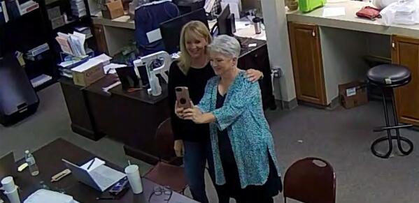 FILE - In this Jan. 7, 2021, image taken from Coffee County, Ga., security video, Cathy Latham, right, appears to take a selfie with a member of a computer forensics team inside the local elections office. Latham was the county Republican Party chair at the time. The computer forensics team was at the county elections office in Douglas, Ga., to make copies of voting equipment in an effort that documents show was arranged by attorney Sidney Powell and others allied with then-President Donald Trump. (Coffee County, Georgia via AP)