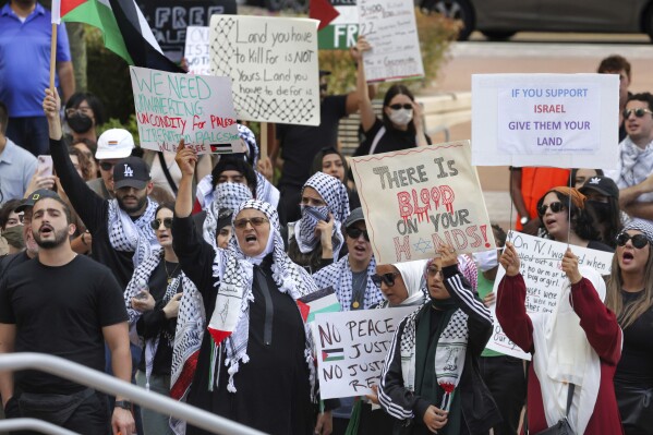 FILE - Pro-Palestinian supporters hold up signs during a demonstration at Orlando City Hall, Friday, Oct. 20, 2023, in Orlando, Fla. State lawmakers across the country are expected consider legislation related to the Israel-Hamas war in 2024. (Joe Burbank/Orlando Sentinel via AP, File)