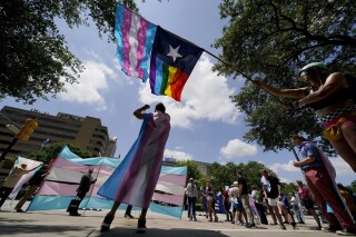 FILE - Demonstrators gather on the steps to the Texas Capitol to speak against transgender-related legislation bills being considered in the Texas Senate and Texas House, May 20, 2021, in Austin, Texas. On Wednesday, July 12, 2023, a group of Texas families and doctors filed suit in federal court seeking to block the state’s new law that bans gender-affirming care for minors, arguing it violates parental rights and discriminates against transgender teens. (AP Photo/Eric Gay, File)
