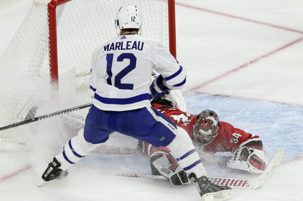 
              Toronto Maple Leafs' Patrick Marleau (12) scores against Carolina Hurricanes goalie Petr Mrazek (34), of the Czech Republic, during the third period of an NHL hockey game in Raleigh, N.C., Tuesday, Dec. 11, 2018. Toronto won 4-1. (AP Photo/Gerry Broome)
            