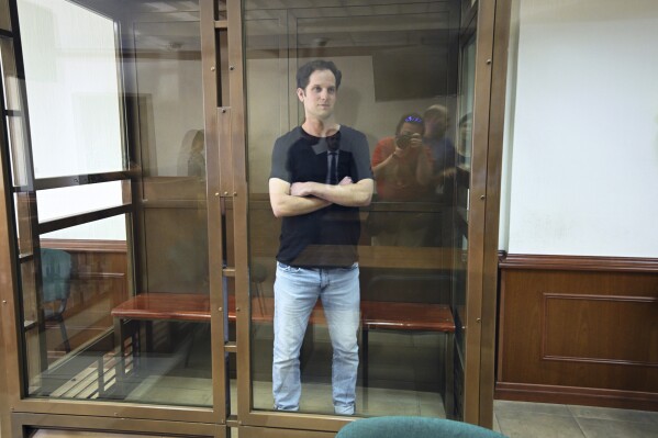 Wall Street Journal reporter Evan Gershkovich stands in a glass cage in a courtroom at the Moscow City Court in Moscow, Russia, Thursday, June 22, 2023. Gershkovich, a Wall Street Journal reporter detained on espionage charges in Russia, appeared in court Thursday to appeal his extended detention. (AP Photo/Dmitry Serebryakov)