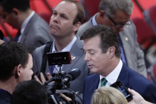 
              FILE - In this July 17, 2016 file photo, President Donald Trump's Campaign Chairman Paul Manafort is surrounded by reporters on the floor of the Republican National Convention in Cleveland. Rick Gates, a former business associate to Manafort and former campaign aide to Republican presidential candidate Donald Trump, is center rear.   (AP Photo/J. Scott Applewhite)
            