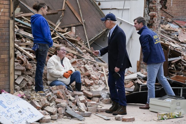 FILE - President Joe Biden and Kentucky Gov. Andy Beshear talk to people as they survey storm damage from tornadoes and extreme weather in Mayfield, Ky., Wednesday, Dec. 15, 2021. Beshear says a rental housing shortage has gnawed at him since the recovery began from a tornado outbreak that hit western Kentucky in 2021. On Monday, June 3, 2024, Beshear unveiled plans to build 953 rental housing units in four counties — Christian, Graves, Hopkins and Warren. (AP Photo/Andrew Harnik, File)