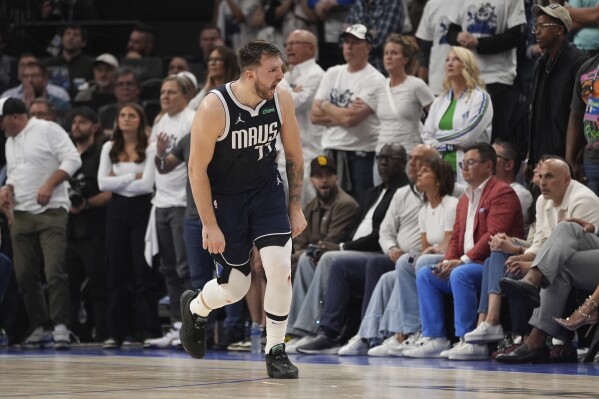 Dallas Mavericks guard Luka Doncic (77) celebrates a score against the Minnesota Timberwolves during the second half in Game 1 of the NBA basketball Western Conference finals, Wednesday, May 22, 2024, in Minneapolis. (AP Photo/Abbie Parr)
