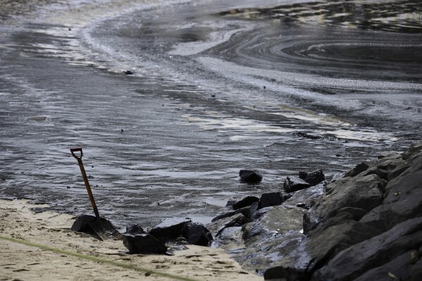 A general view of oil spill along Sentosa's Tanjong Beach area in Singapore, Sunday, June 16, 2024. An oil spill caused by a dredger boat hitting a stationary cargo tanker has blackened part of Singapore’s southern coastline, including the popular resort island of Sentosa, and sparked concerns it may threaten marine wildlife. (AP Photo/Suhaimi Abdullah)