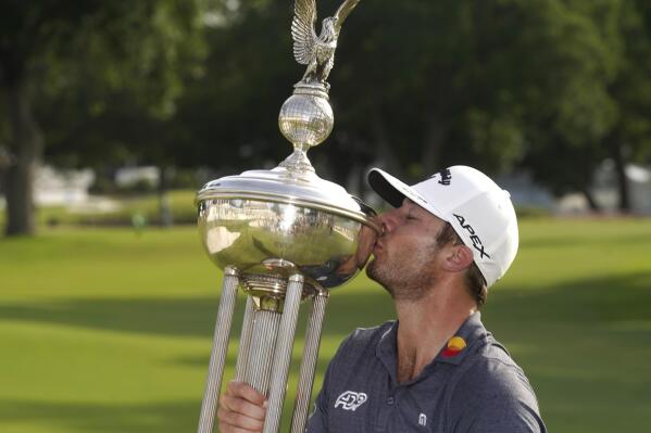 Sam Burns kisses the trophy after winning the Charles Schwab Challenge golf tournament at the Colonial Country Club in Fort Worth, Texas, Sunday, May 29, 2022. (AP Photo/LM Otero)
