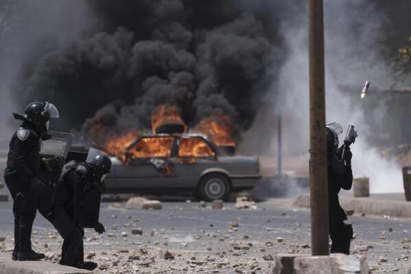 A riot police officer shots tear gas at demonstrators during a protest at the Cheikh Anta Diop University campus in Dakar, Senegal, Thursday, June 1, 2023. Senegal opposition leader Ousmane Sonko was convicted Thursday of corrupting youth but acquitted on charges of raping a woman who worked at a massage parlor and making death threats against her. (AP Photo/Leo Correa)