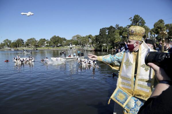 FILE - In this Wednesday, Jan. 6, 2021 file photo, His Eminence Archbishop Elpidophoros, Primate of the Greek Orthodox Archdiocese of America throws a cross into Spring Bayou during the 115th year of the annual Epiphany celebration in Tarpon Springs, Fla. Leaders of the Greek Orthodox Archdiocese of America said Thursday, Sept. 16, 2021, that while some people may have medical conditions for not receiving the vaccine, “there is no exemption in the Orthodox Church for Her faithful from any vaccination for religious reasons.” Greek Orthodox Archbishop Elpidophoros added: “No clergy are to issue such religious exemption letters,” and any such letter “is not valid.” (Douglas R. Clifford/Tampa Bay Times via AP)
