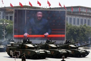 FILE - In this Thursday, Sept. 3, 2015 file photo, Chinese President Xi Jinping is displayed on a screen as Type 99A2 Chinese battle tanks take part in a parade commemorating the 70th anniversary of Japan's surrender during World War II held in front of Tiananmen Gate in Beijing. Seventy-five years after Japan's surrender in World War II, and 30 years after its economic bubble popped, the emergence of a 21st century Asian power is shaking up the status quo. As Japan did, China is butting heads with the established Western powers, which increasingly see its growing economic and military prowess as a threat. (AP Photo/Ng Han Guan, File)