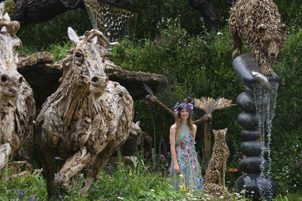 Cordelia Bellew walks through a garden displaying James Doran-Webb Driftwood Sculptures at the RHS Chelsea Flower Show in London, Monday, May 19, 2025. (AP Photo/Kirsty Wigglesworth)