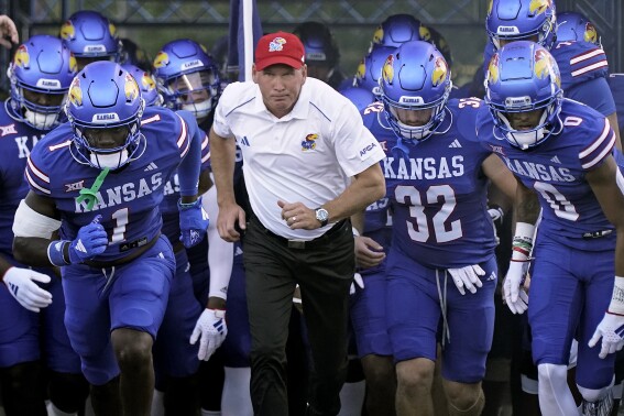 FILE - Kansas head coach Lance Leipold leads his team onto the field before an NCAA college football game against Missouri State Friday, Sept. 1, 2023, in Lawrence, Kan. Kansas football coach Lance Leipold signed an amended contract that increased his overall compensation to more than $40 million through the 2029 season. (AP Photo/Charlie Riedel, File)