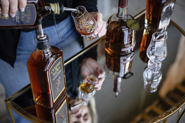 An employee pours a glass of The Bard's product in what will be a new production area at The Bard Distillery in Graham, Ky., Sunday, March 9, 2025. (AP Photo/Jon Cherry)